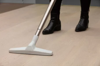 Person vacuuming hardwood floor