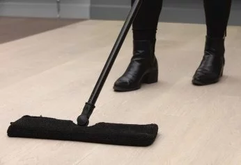 Person mopping hardwood flooring