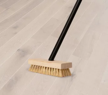 Person brushing hardwood flooring